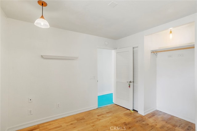 unfurnished bedroom featuring hardwood / wood-style floors and a closet