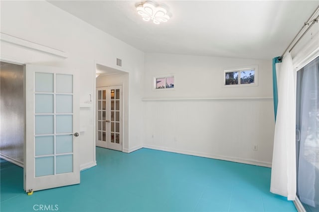 unfurnished room featuring french doors and vaulted ceiling