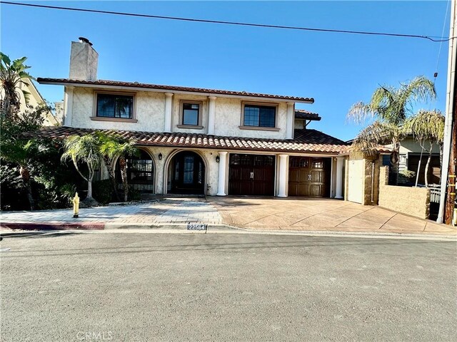 mediterranean / spanish-style house with a garage