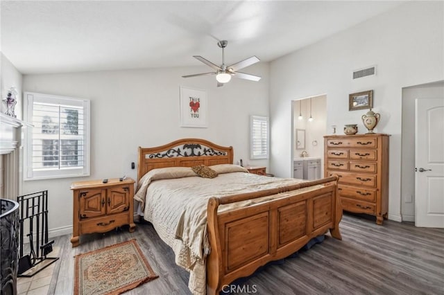 bedroom with lofted ceiling, dark hardwood / wood-style flooring, ceiling fan, and ensuite bathroom