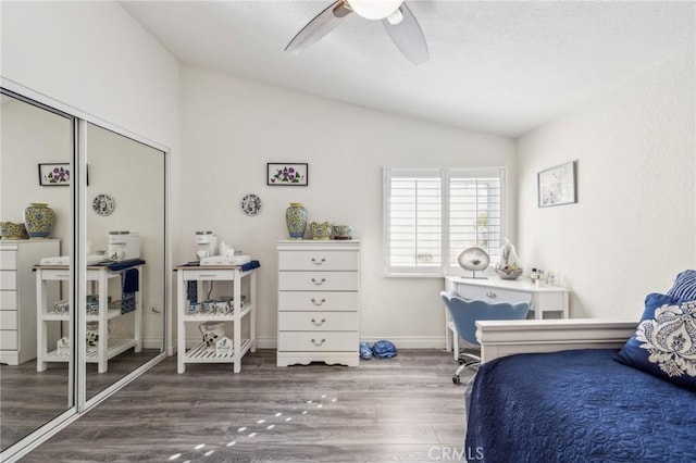 bedroom featuring vaulted ceiling, wood-type flooring, ceiling fan, and a closet