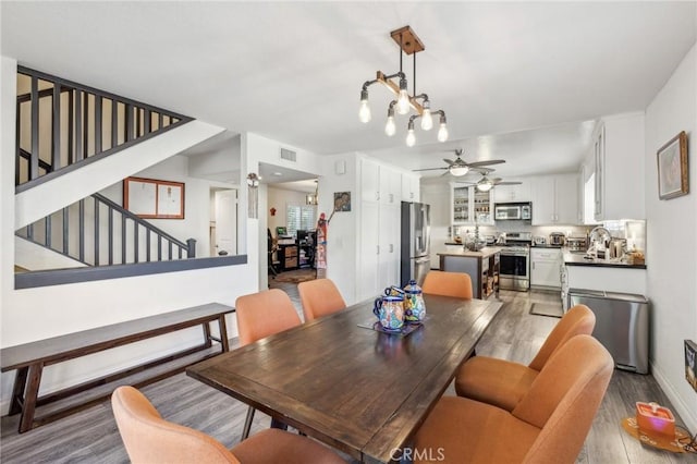 dining room featuring hardwood / wood-style floors, sink, and ceiling fan