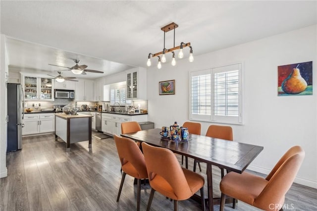 dining area featuring dark hardwood / wood-style floors, sink, and ceiling fan