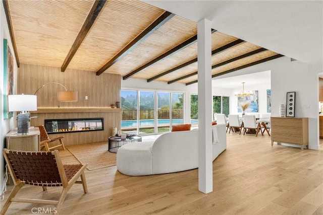 living room featuring wood-type flooring, wooden walls, a large fireplace, lofted ceiling with beams, and wooden ceiling