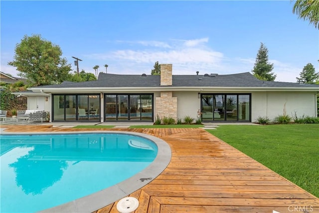 view of pool with a deck and a yard