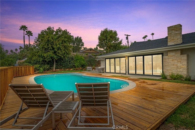 pool at dusk with a deck