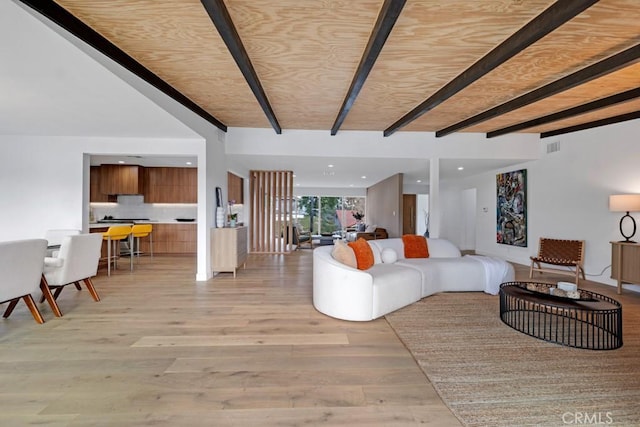 living room with light hardwood / wood-style floors and beam ceiling