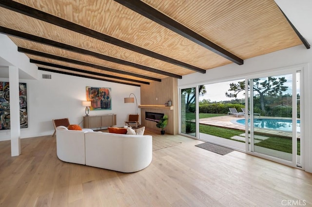 living room featuring a fireplace, light hardwood / wood-style floors, lofted ceiling with beams, and wooden ceiling