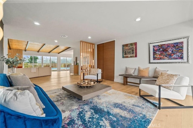 living room featuring vaulted ceiling and light hardwood / wood-style flooring