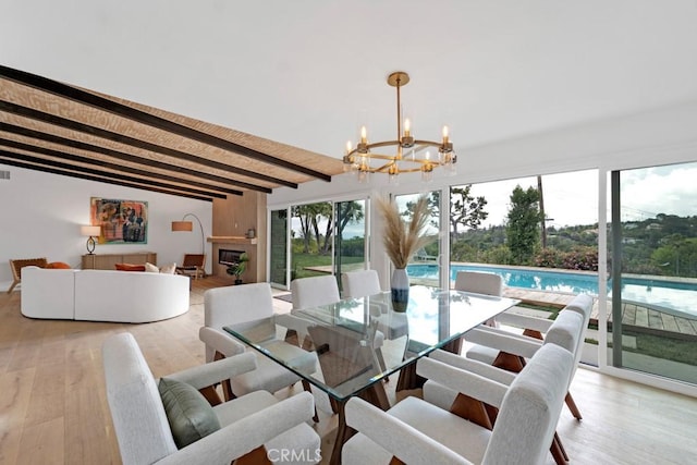 dining room with light hardwood / wood-style floors, beamed ceiling, and an inviting chandelier