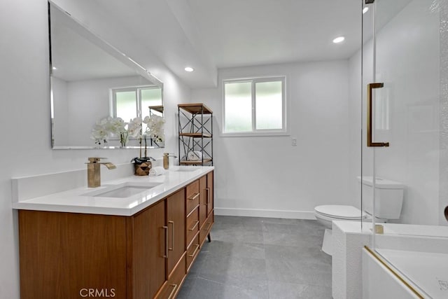 bathroom with toilet, vanity, a wealth of natural light, and a shower with shower door