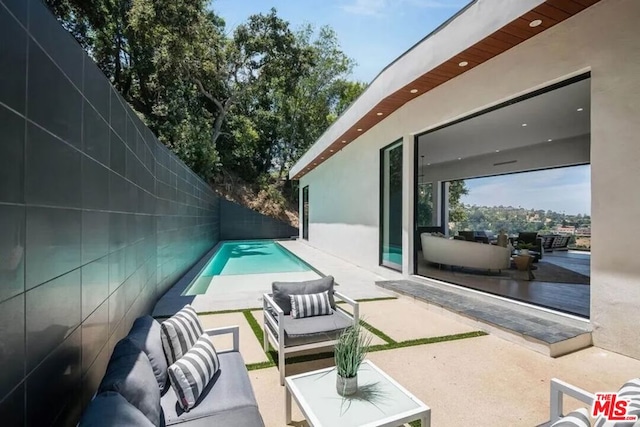 view of patio / terrace with an outdoor living space and a fenced in pool