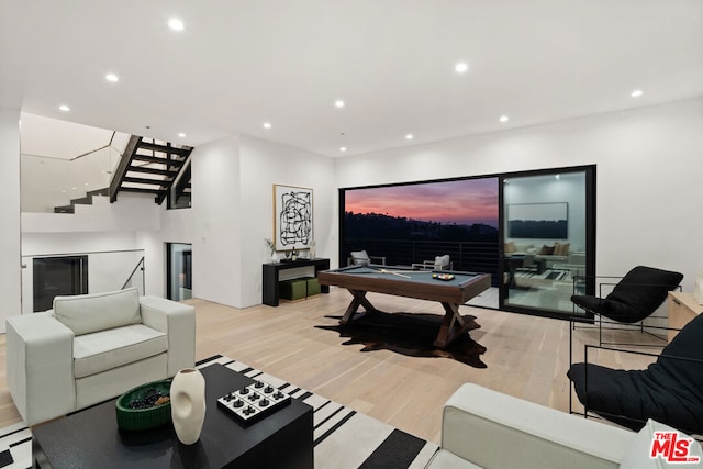 living room with billiards and light hardwood / wood-style flooring