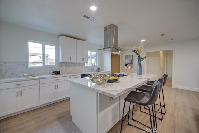 kitchen featuring island range hood, a center island, dishwasher, and white cabinets