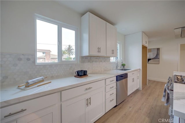 kitchen with sink, white cabinets, decorative backsplash, stainless steel appliances, and light stone countertops