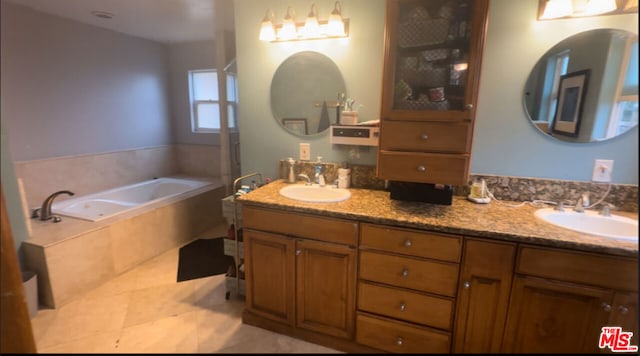 bathroom with a relaxing tiled tub, tile patterned floors, and vanity