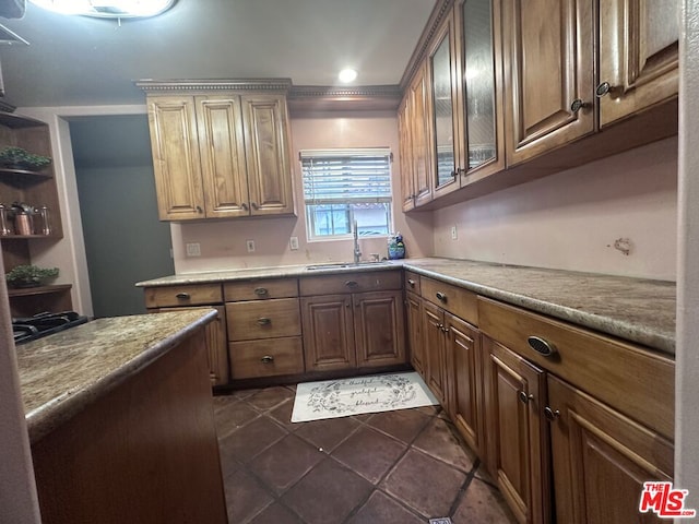 kitchen with dark tile patterned floors, sink, and ornamental molding