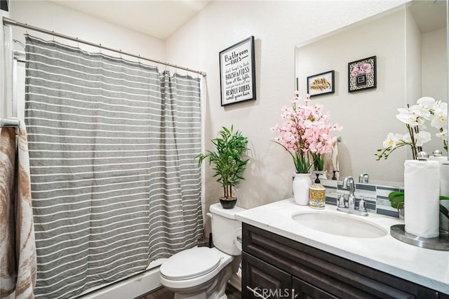 bathroom with toilet, vanity, and walk in shower