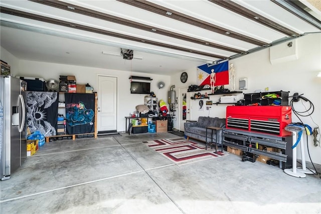 garage featuring stainless steel fridge and a workshop area