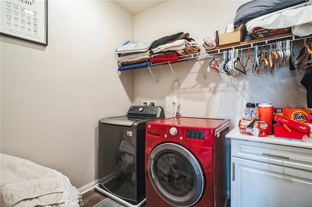 washroom featuring cabinets, hardwood / wood-style floors, and washing machine and clothes dryer