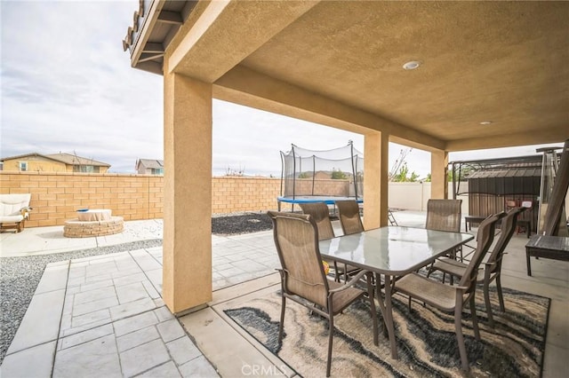 view of patio / terrace with an outdoor fire pit and a trampoline