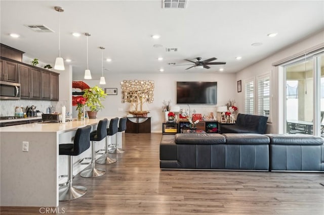 living room with ceiling fan and light hardwood / wood-style flooring