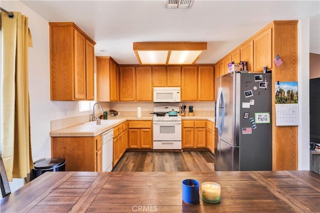 kitchen featuring tile counters, dark wood-type flooring, sink, and white appliances