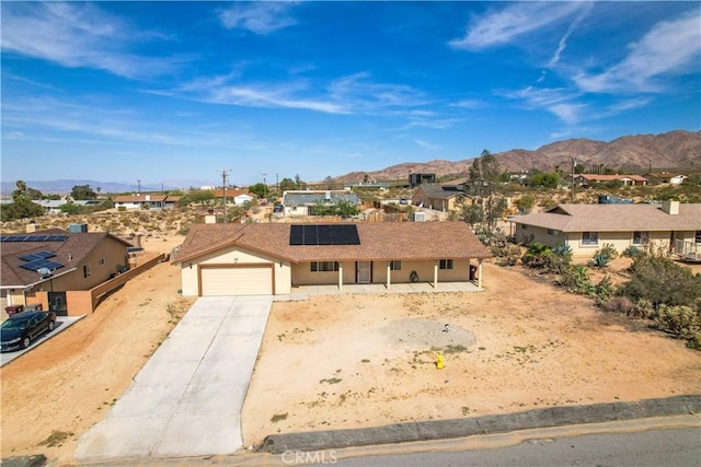 view of front of home with a mountain view, a garage, and solar panels