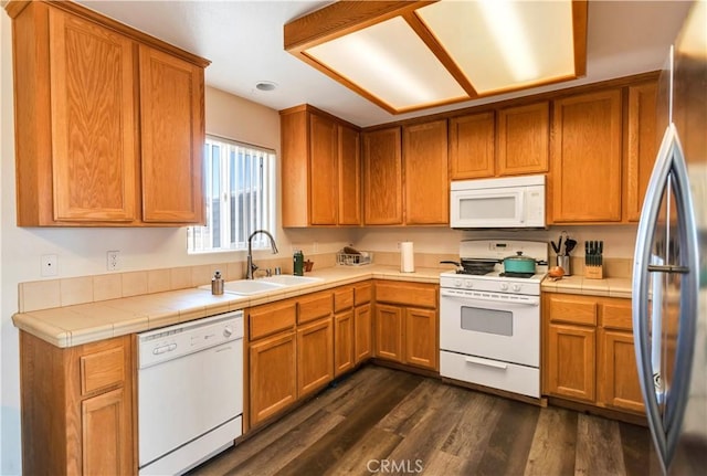 kitchen with dark wood-type flooring, tile countertops, sink, and white appliances