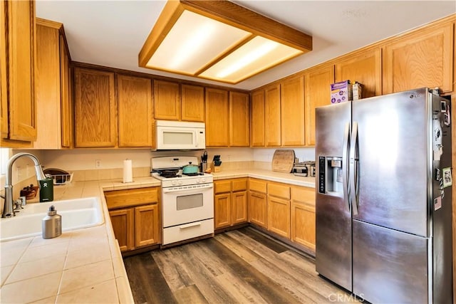 kitchen featuring tile countertops, dark wood-type flooring, sink, and white appliances