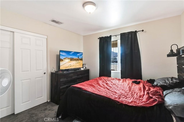 bedroom with dark carpet and a closet