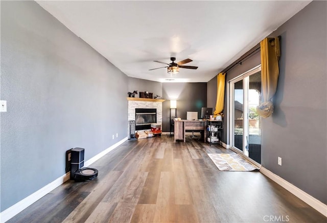 interior space with ceiling fan, a fireplace, and hardwood / wood-style flooring