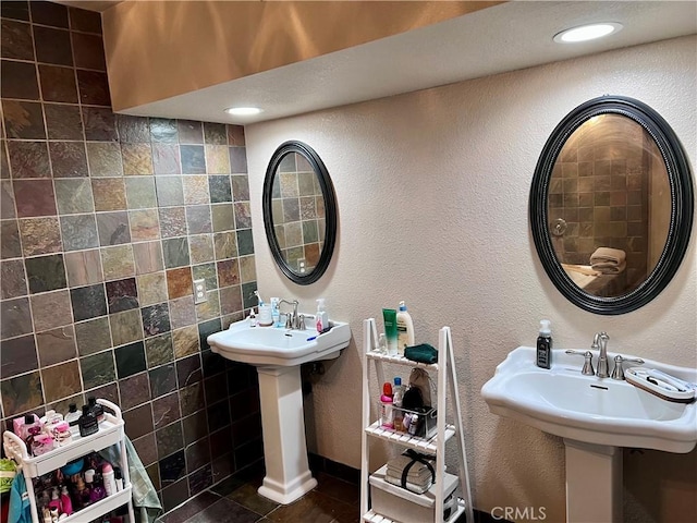 bathroom featuring sink and tile walls