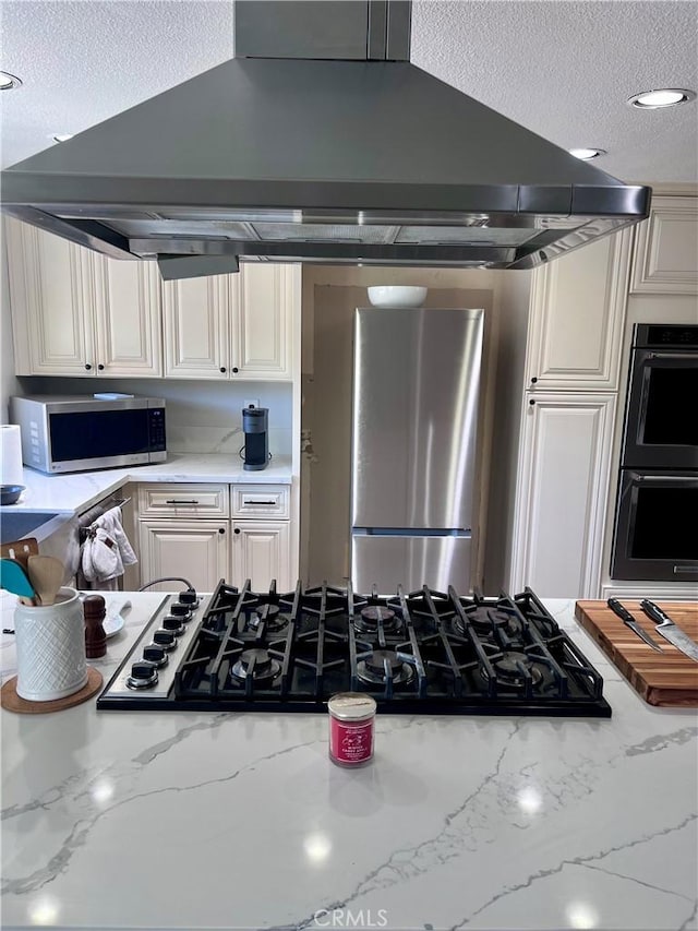 kitchen with light stone counters, a textured ceiling, black appliances, and island exhaust hood