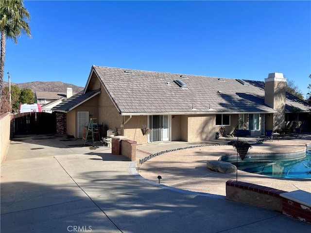 back of house with a mountain view and a patio