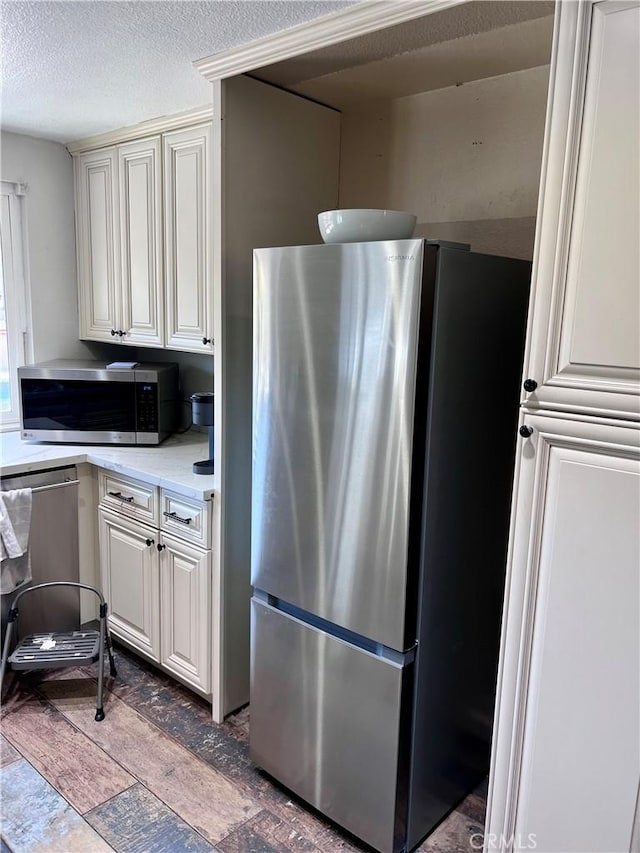 kitchen with a textured ceiling and appliances with stainless steel finishes