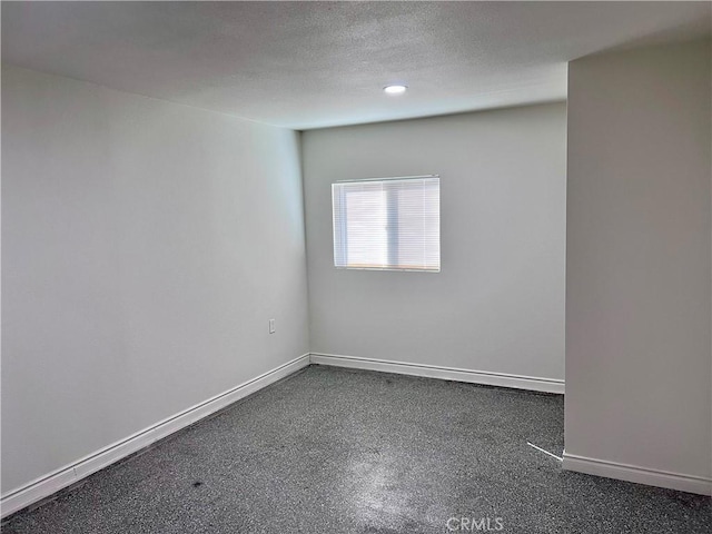 unfurnished room with a textured ceiling