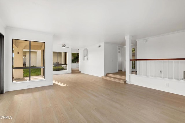 unfurnished living room with ceiling fan, crown molding, and light hardwood / wood-style floors