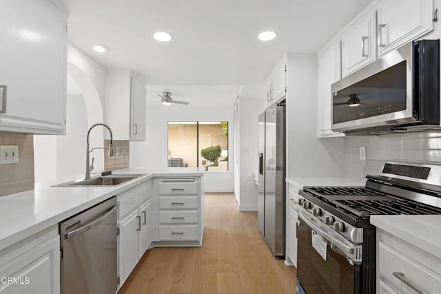 kitchen with sink, white cabinets, light hardwood / wood-style flooring, and stainless steel appliances