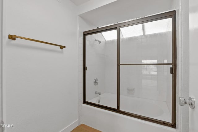 bathroom featuring combined bath / shower with glass door