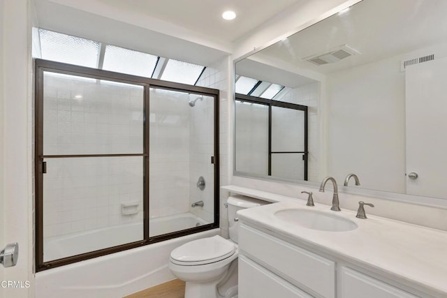 full bathroom featuring toilet, enclosed tub / shower combo, and vanity