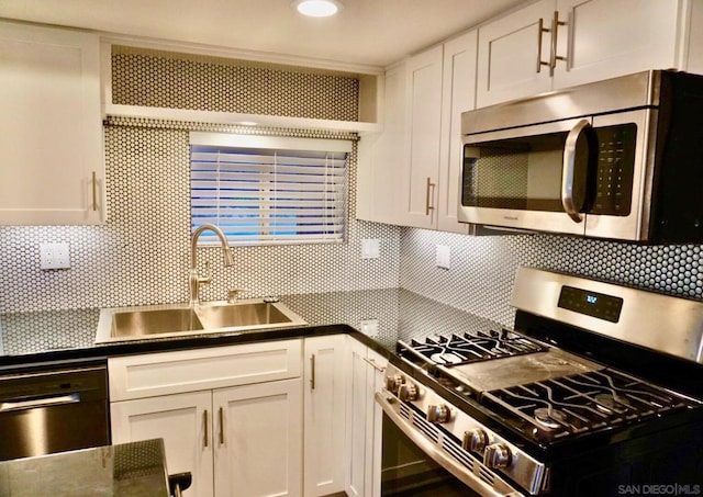 kitchen featuring backsplash, sink, white cabinets, and appliances with stainless steel finishes