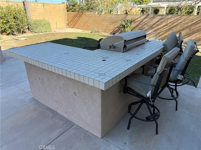 view of patio with a bar and a grill