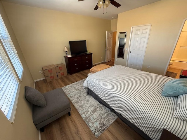 bedroom with wood-type flooring, connected bathroom, and ceiling fan