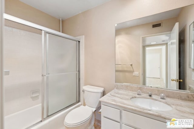 full bathroom with toilet, vanity, and shower / bath combination with glass door