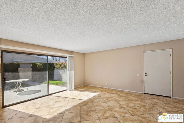 tiled spare room featuring a textured ceiling