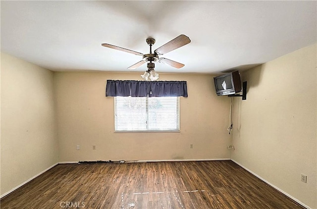 empty room with ceiling fan and dark hardwood / wood-style flooring