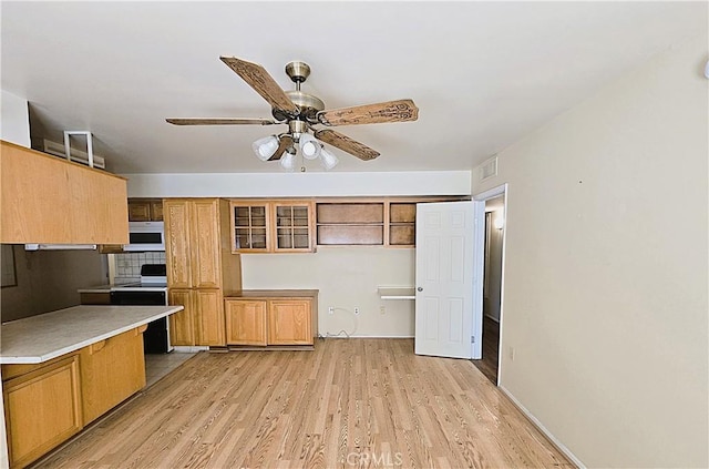 kitchen featuring ceiling fan, backsplash, light hardwood / wood-style flooring, and range with electric stovetop