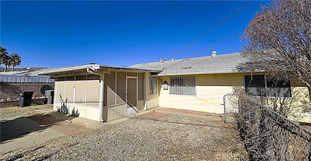 back of property with a sunroom