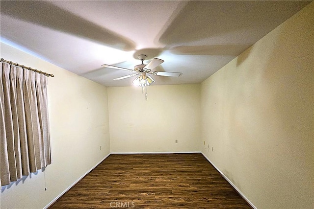 spare room featuring ceiling fan and dark wood-type flooring